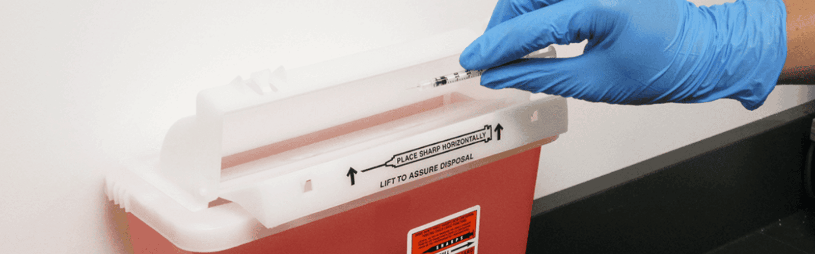 Sharps container with glove